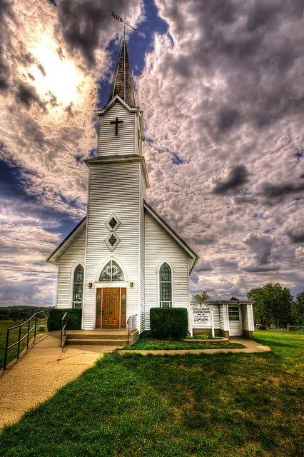 Traditional white church beneath a dramatic sky